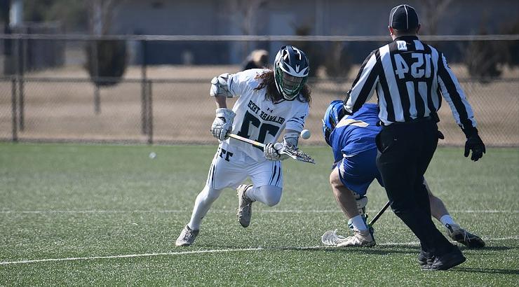 Louis Savino of Delaware Tech wins a face-off against an opponent from Carroll Community College during a game on Feb. 26 at the DE Turf Sports Complex.